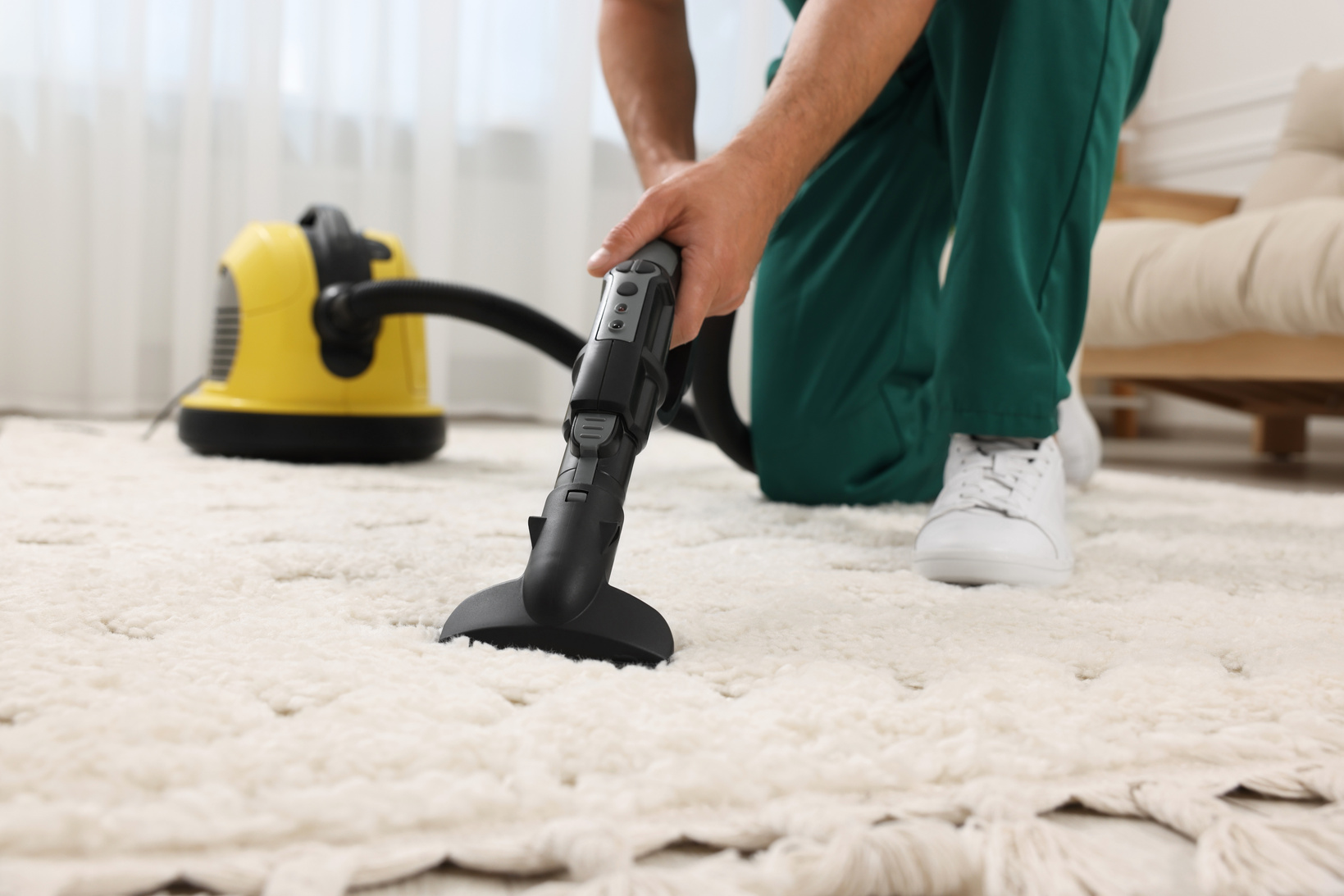 Dry Cleaner's Employee Hoovering Carpet with Vacuum Cleaner Indo