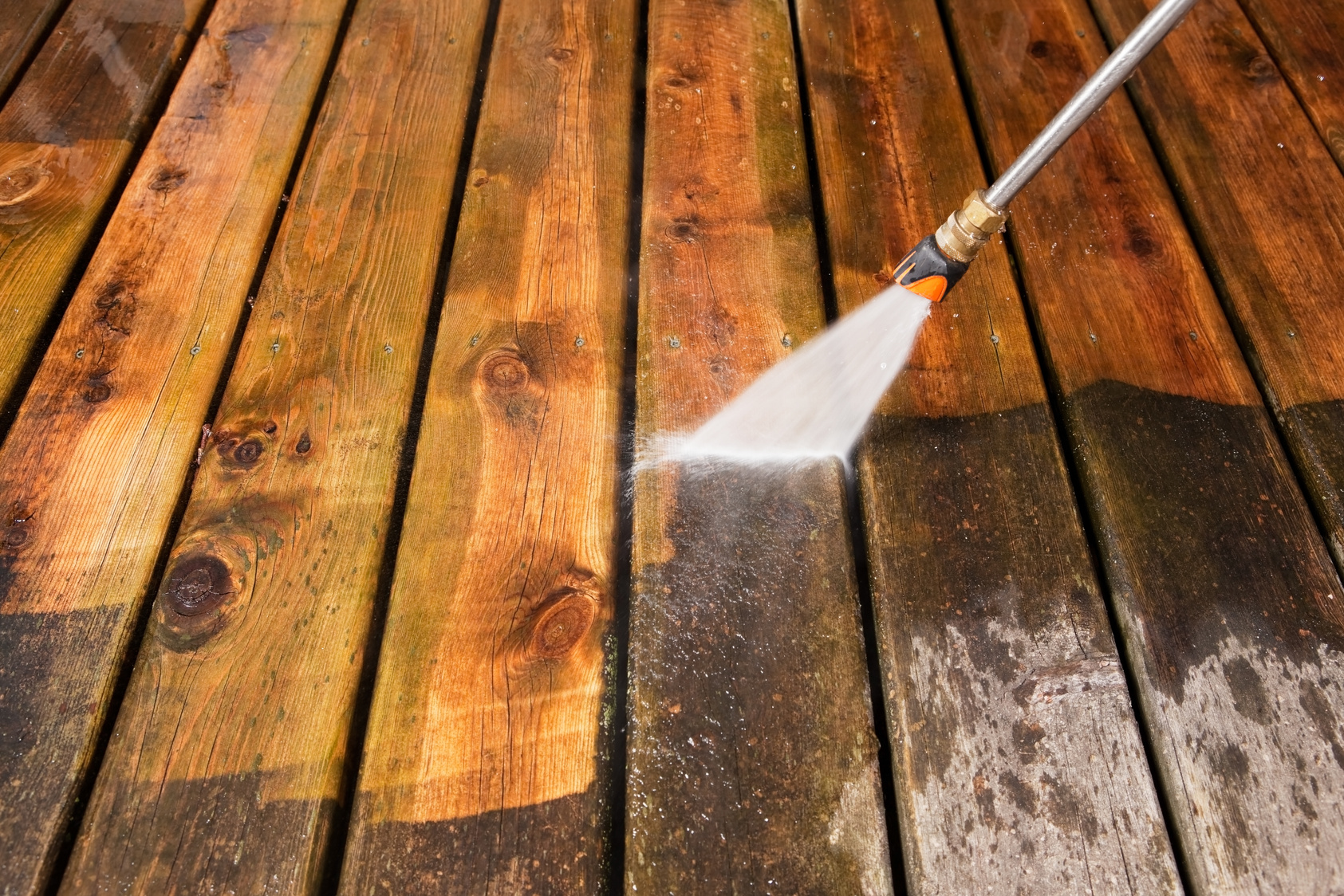 Pressure Washer Cleaning a Weathered Deck